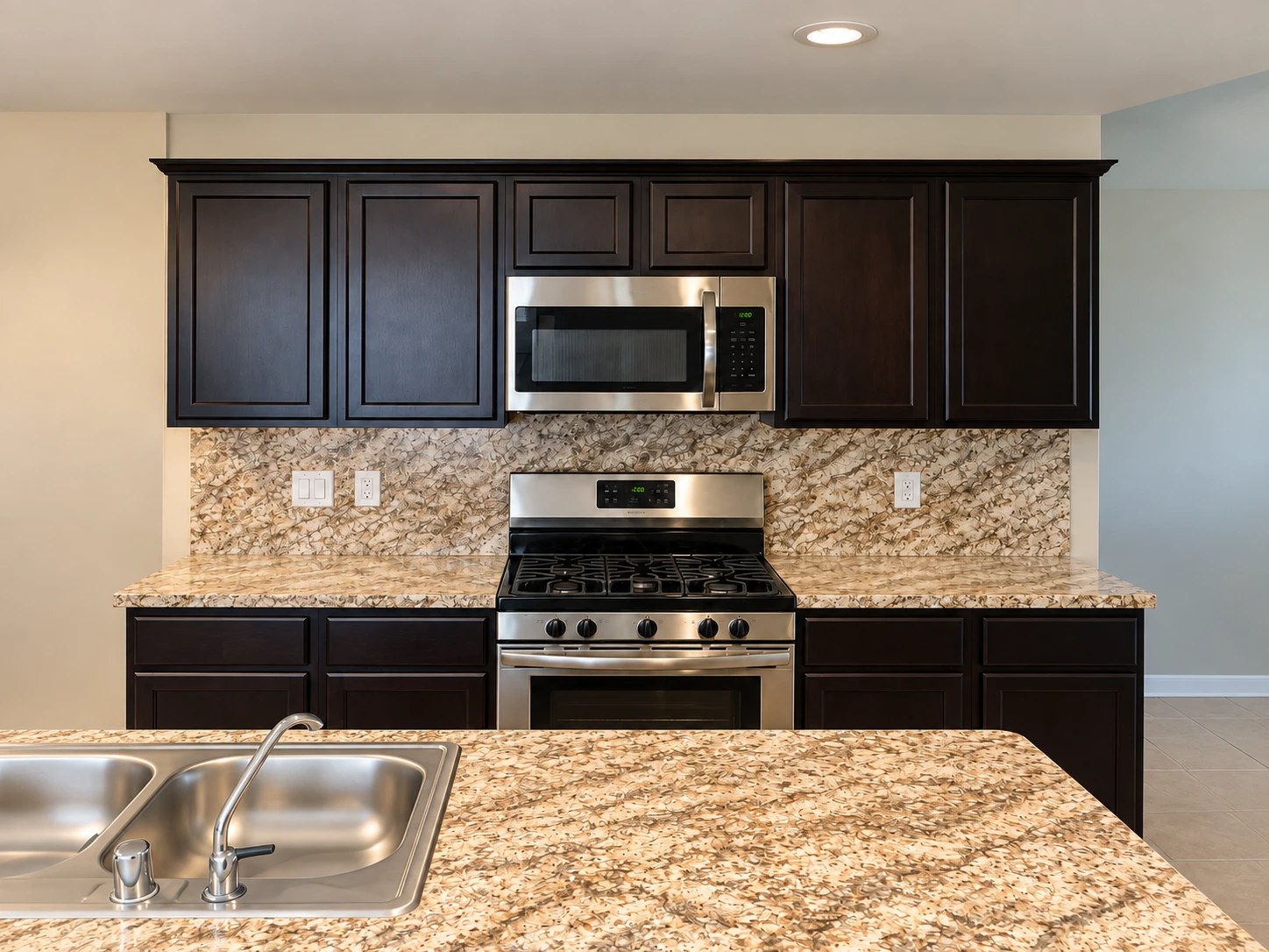Kitchen before renovation: dark cabinets, granite countertops and backsplash